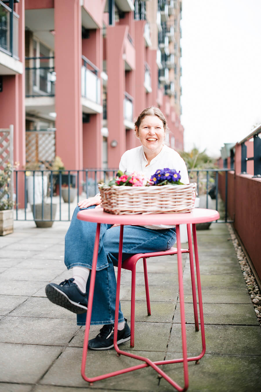 Joline zit aan tafel op haar balkon.