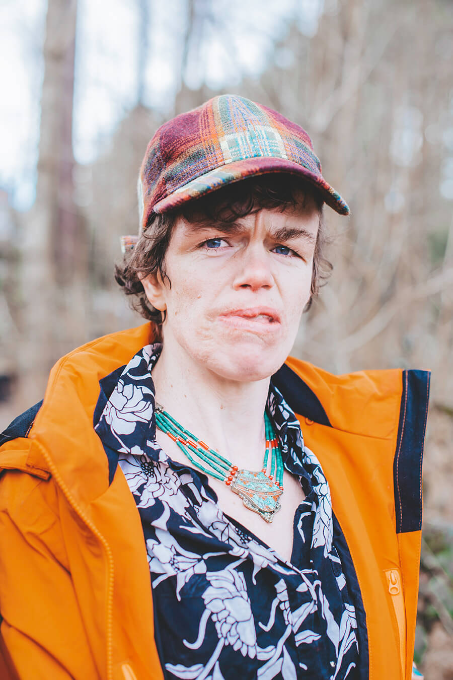 Thiandi van dichtbij in het bos. Ze heeft een groene kralenketting om.